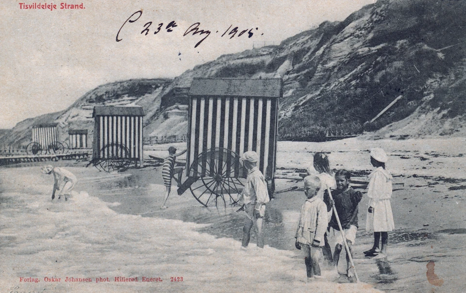 Tisvildeleje Strand med badehuse, ca. 1905. Tisvilde Badehotel havde deres egne badehuse med hjul, så gæsterne ugeneret kunne gå i vandet. Landliggere som familien Cold lejede deres eget badehus for sommeren. 