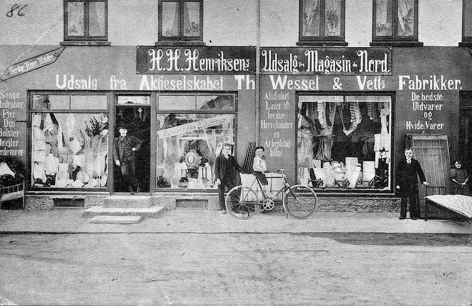 H.H. Henriksen i døren foran sin første forretning på Vesterbrogade 11 i Gilleleje, ca. 1910.  